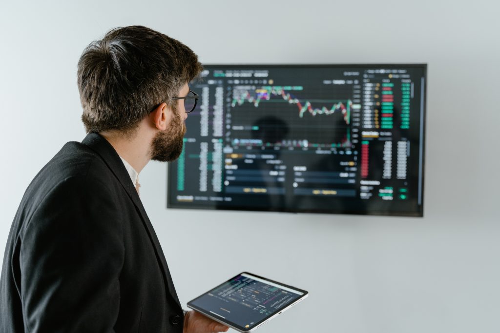 uomo guarda schermo con dati finanziari